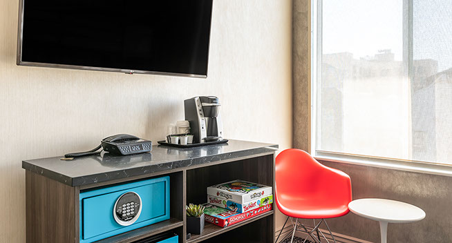 photo showing flat screen television, safe, direct dial phone, and keurig coffe maker. We provide games for entertainment and fun.