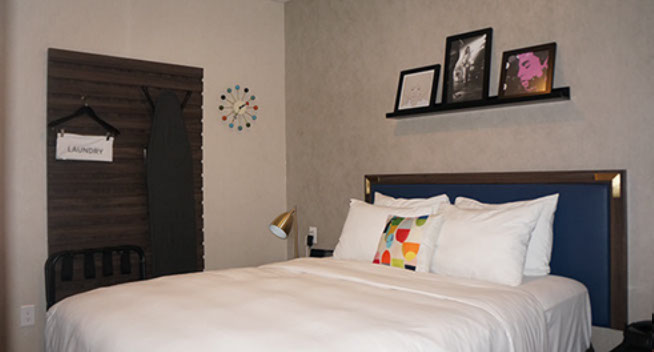 Full size bed with suitcase holder and laundry bag. Lamp with night stand.