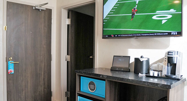 This view shows your room entrance equipped with a flat screen television, ice bucket, Aavgo for communication, Keurig coffee maker safe.