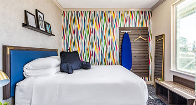 Comfy white linens on a king size bed, with large windows to look over the city. Ironing board and iron provided in room.